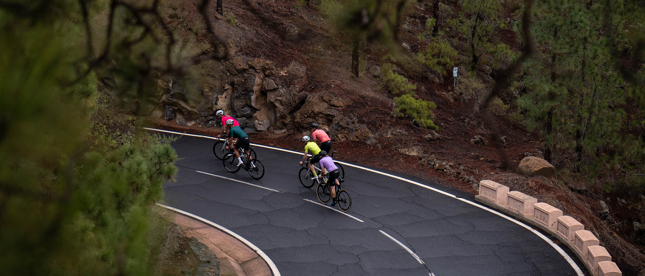 five testers ride road bikes on serpentine road in Tenerife wearing Luxa cycling premium apparel